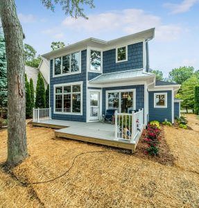 Blue shake two story home with small deck