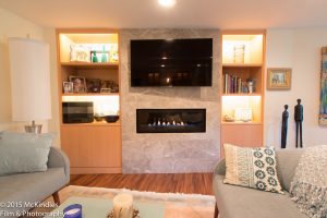 Horizontal fireplace in tile surround with TV above
