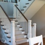 Wood stairway with carpet runner and painted ballusters