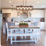 White farmhouse table with kitchen beyond