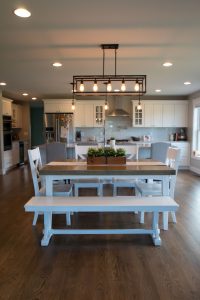 White farmhouse table with kitchen beyond