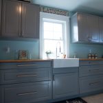Grey laundry room cabinets with farmhouse sink