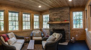 Cedar paneled sunroom with stone fireplace