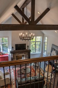 View of fireplace is framed by guard rail and timber trusses