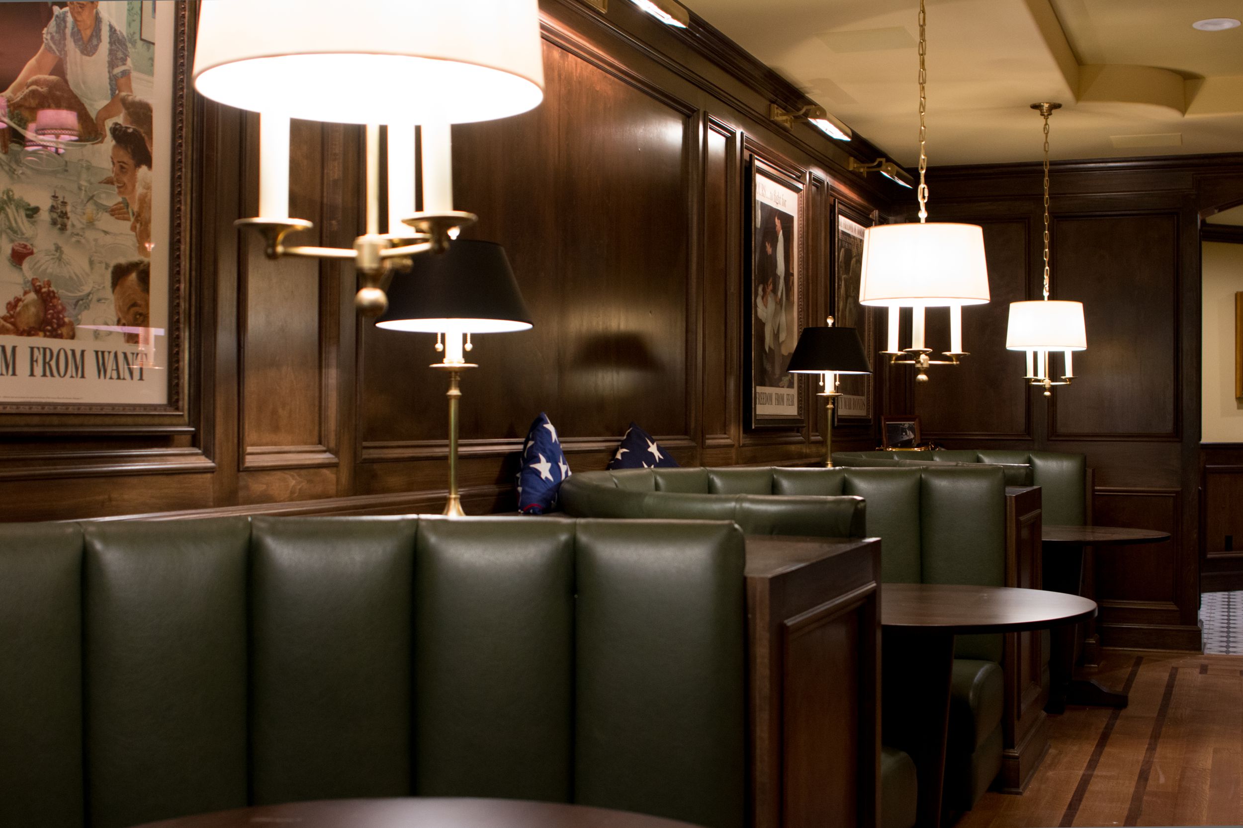 Green leather booths with rich wood paneling