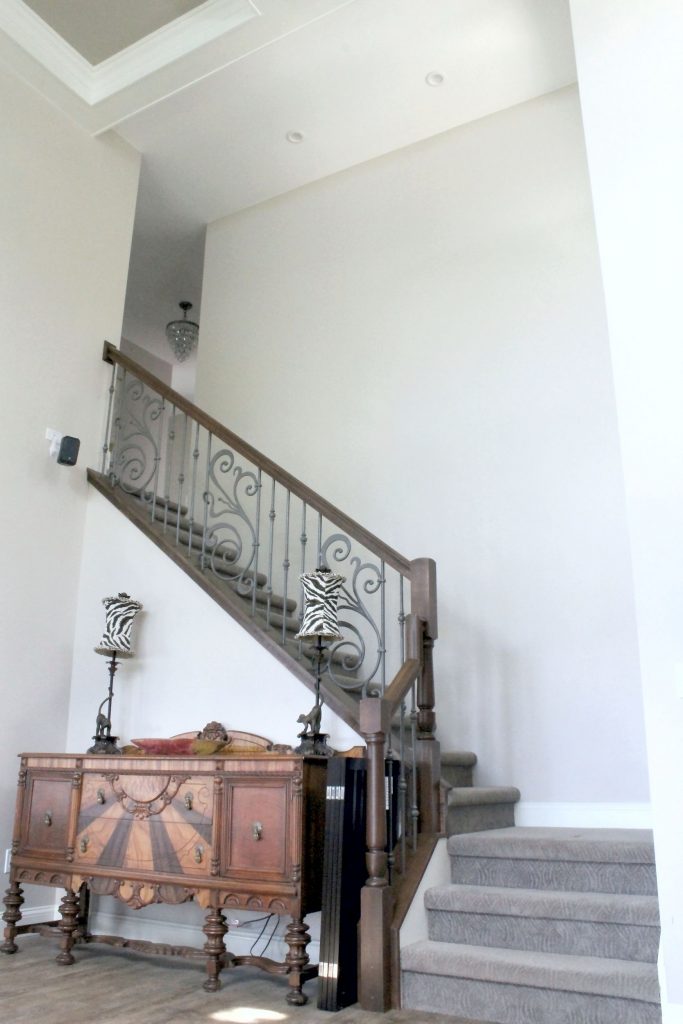 Staircase with wood railing and decorative iron ballusters