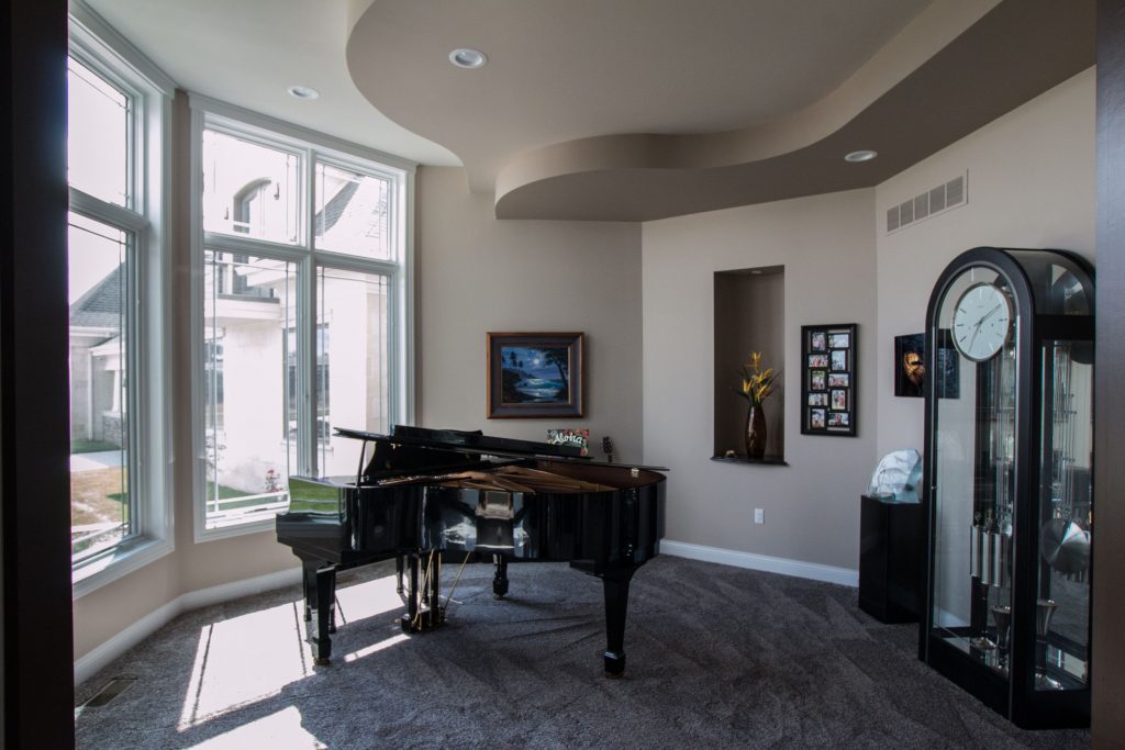 Grand piano in room with curved stepped ceiling details