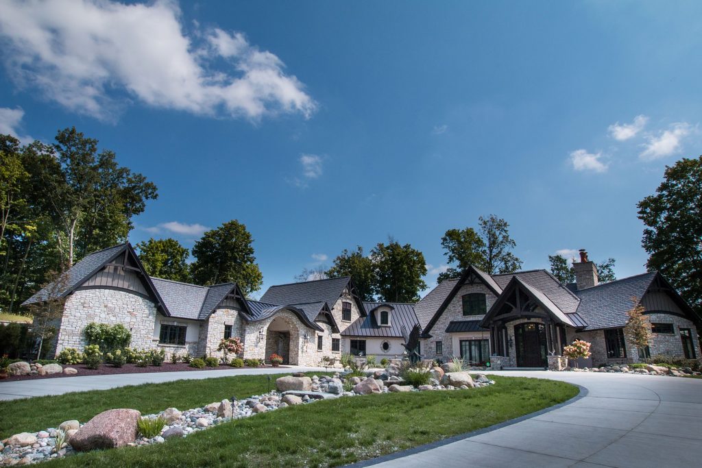 Front view of sprawling home with stone finish and timber accents